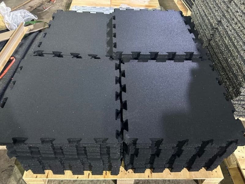 A forklift unloading a pallet of rubber gym flooring rolls at a warehouse.
